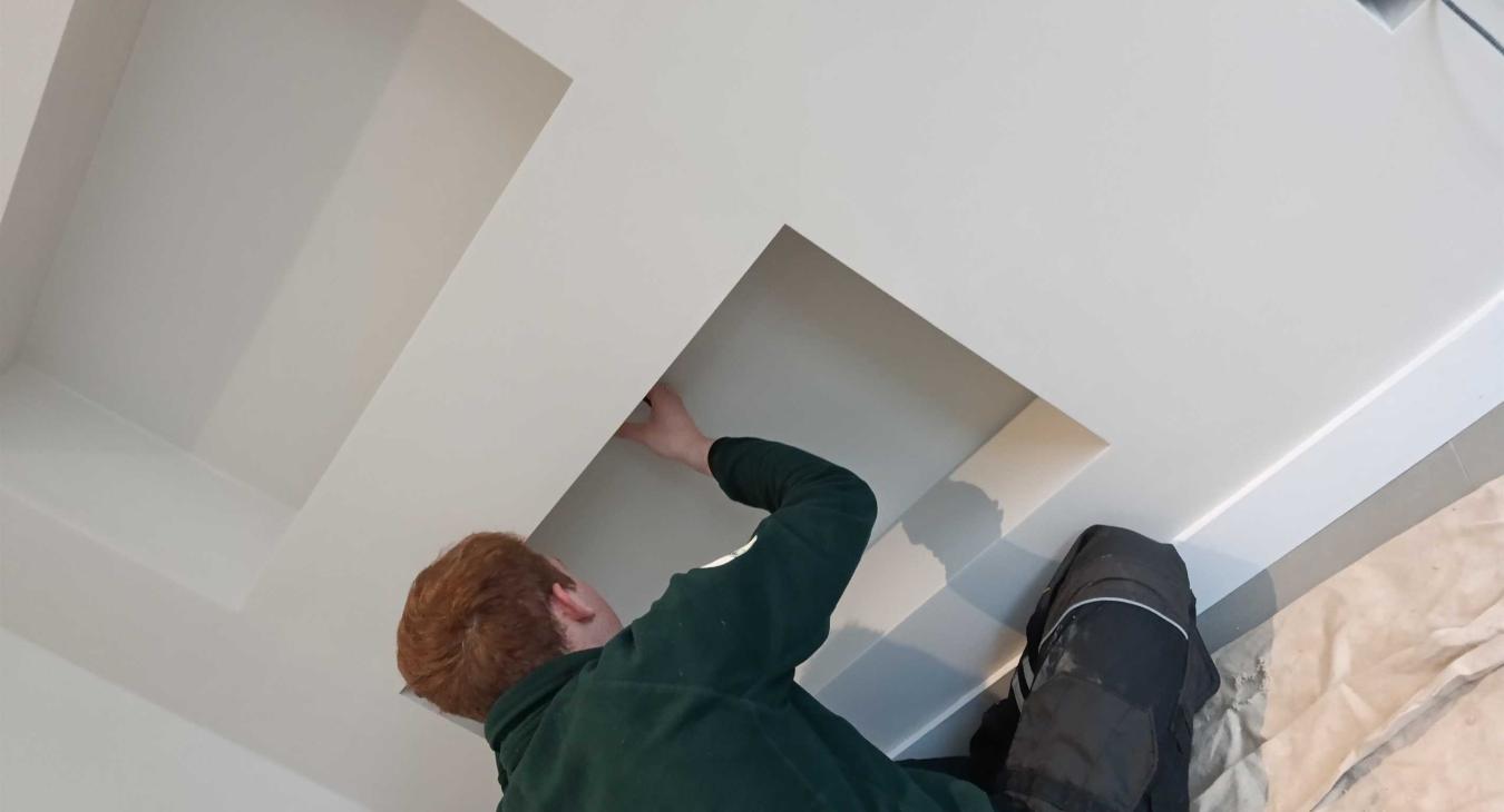 Electrician in Bearsted measuring out for downlights